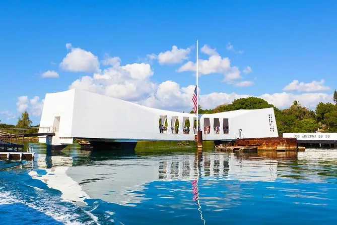 The USS Arizona Memorial seen from the water with its flag at the center