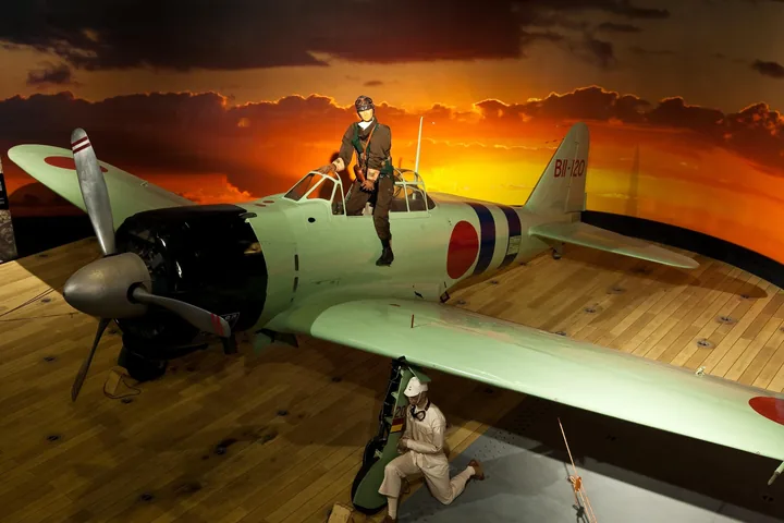 Un caccia Zero giapponese esposto accanto a uno sfondo dipinto al tramonto al museo dell'aviazione di Pearl Harbor